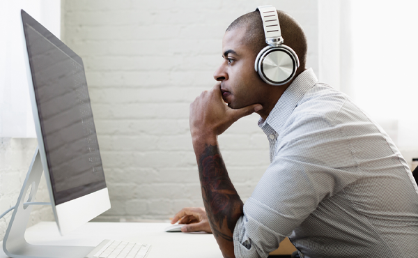 Man wearing headphones while at a computer
