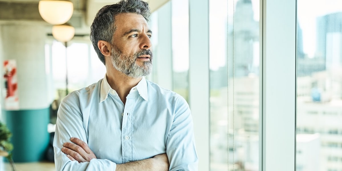 man in office, looking out window