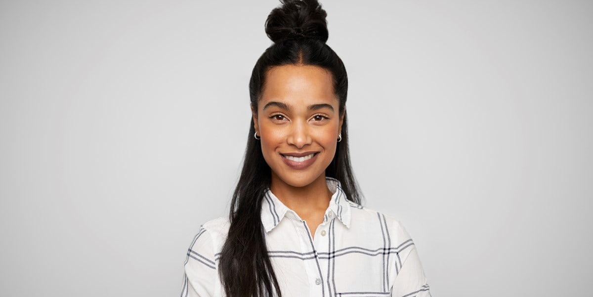 woman smiling in front of grey background