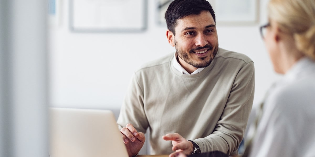 man in office, talking to colleague