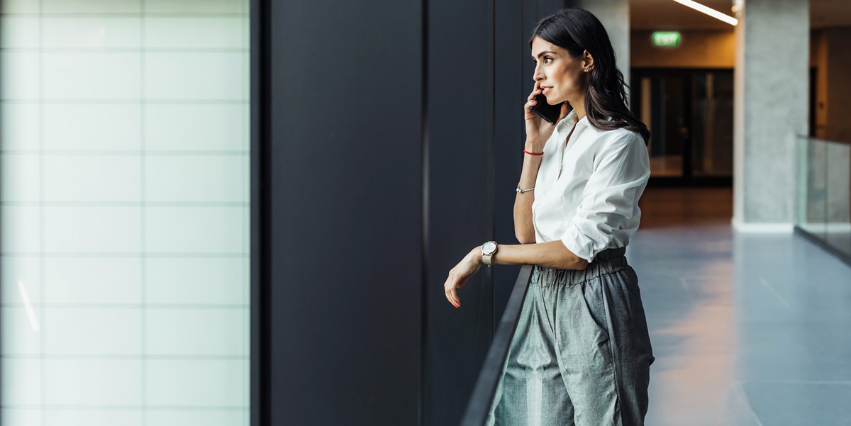 woman in office looking out window, on the phone