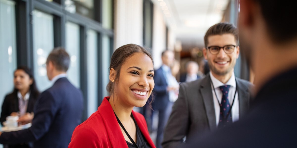 woman in business attire, speaking to group of people