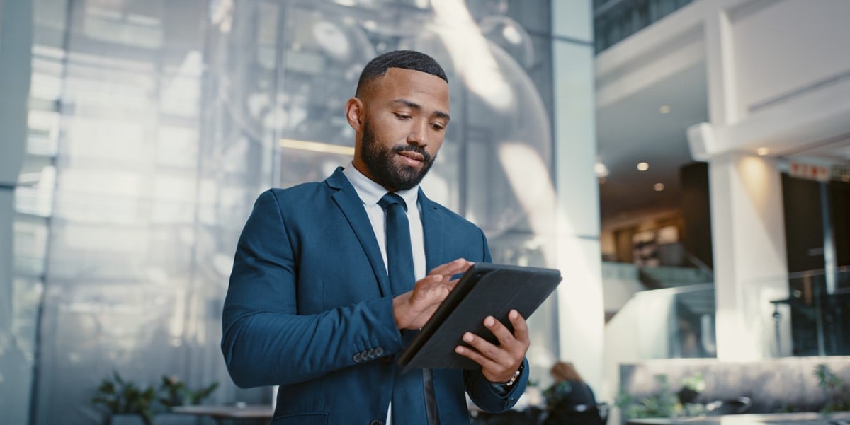 professional in the office, looking down at tablet in hands