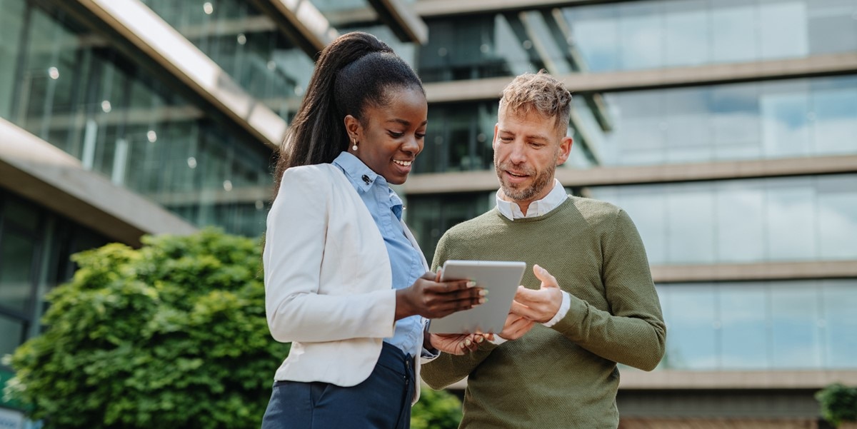 two people looking at a document together, outside of office building