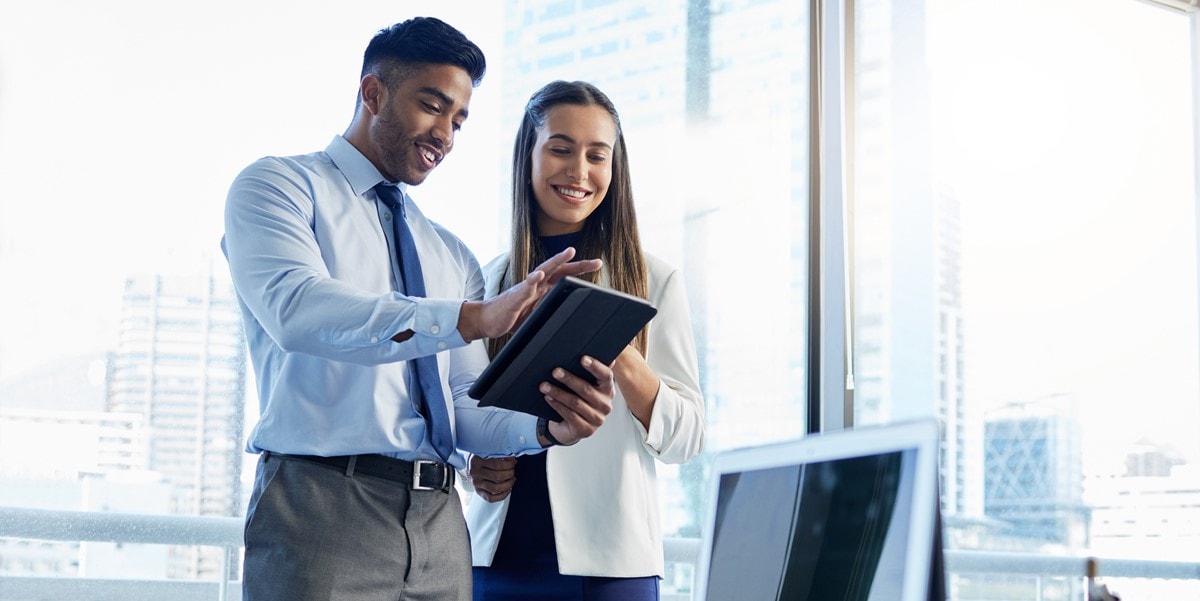 two professionals in office looking at a document