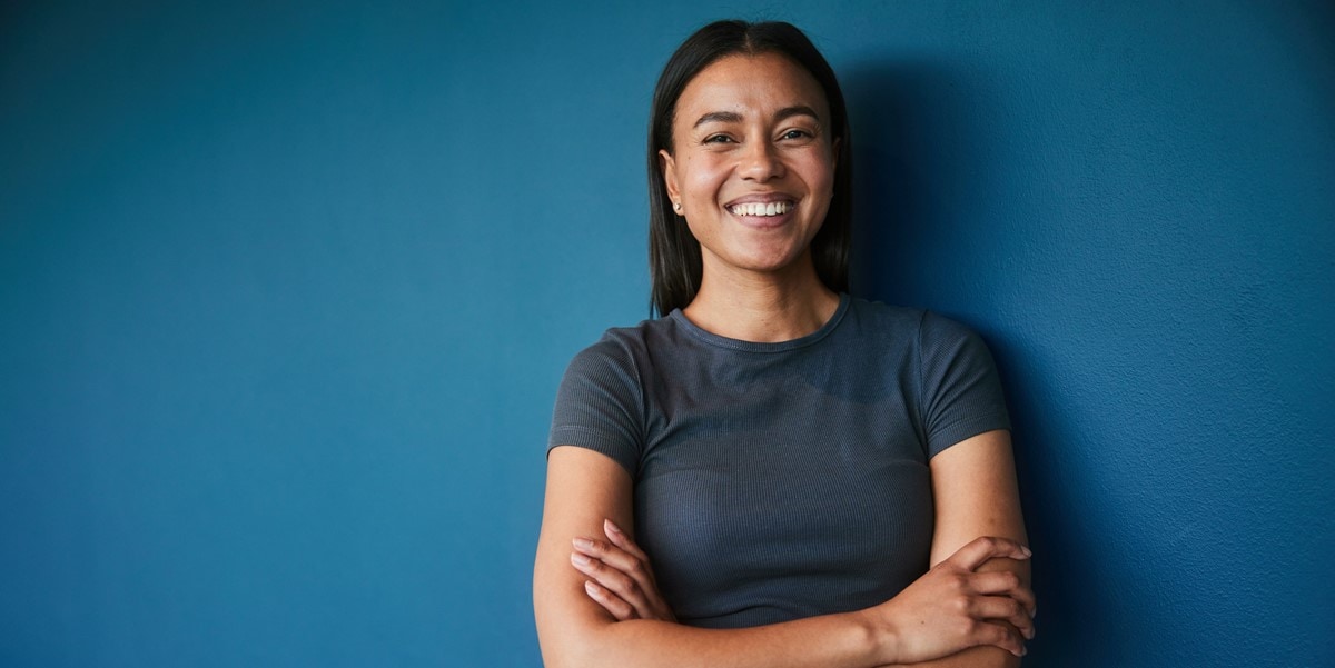 woman smiling in front of blue background