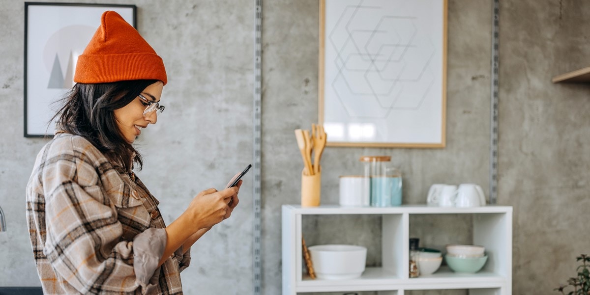 woman in shop, looking at phone in hand