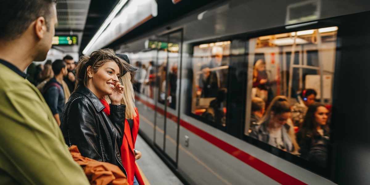 group of people waiting for train, woman smiling