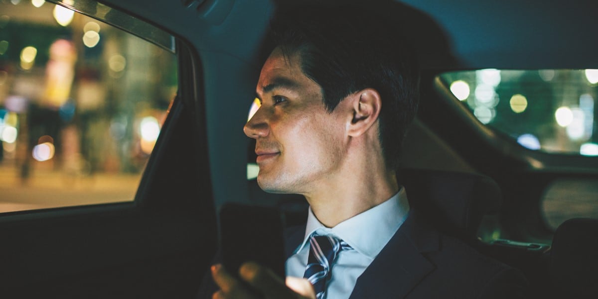 business traveler in car, looking out window